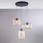 Sospensione in ferro laccato nero con cavi elettrici regolabili e diffusori in vetro soffiato ambra con decoro rigatura in rilievo 3 luci